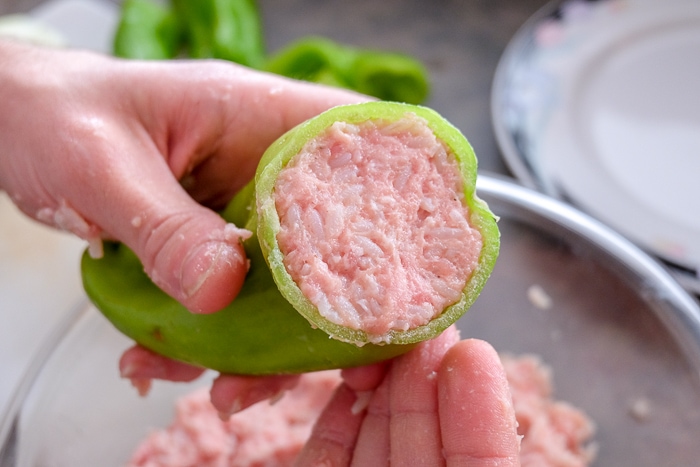 green pepper held in hand stuffed with pork and rice mixture