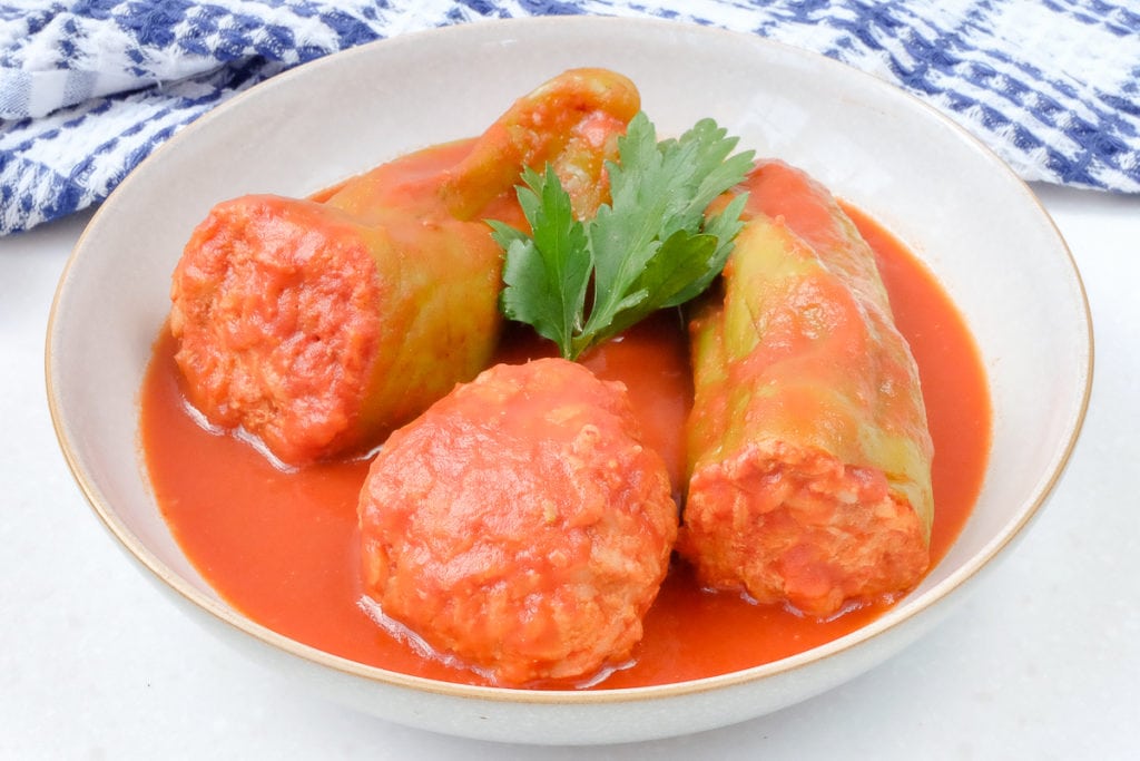 hungarian stuffed peppers in red tomato sauce in white bowl