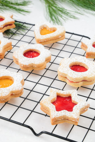 shaped linzer cookies with jam on cookie cooling tray