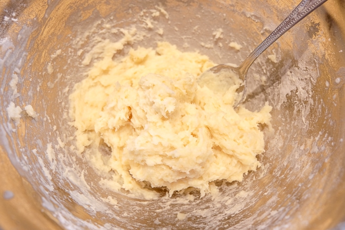 ball of churros dough in metallic mixing bowl