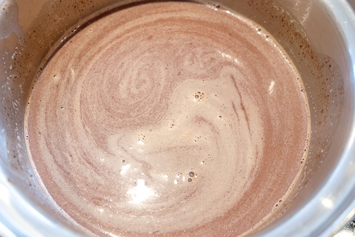 melting chocolate in milk in pot for spanish hot chocolate