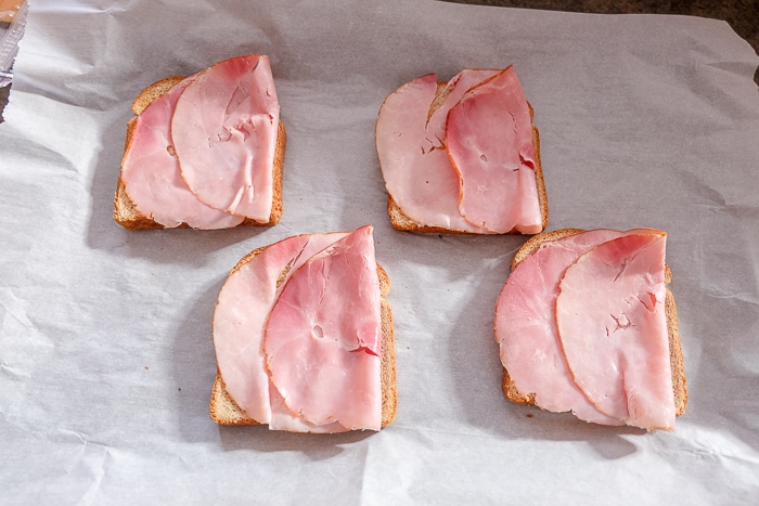 slices of ham on toast on baking sheet