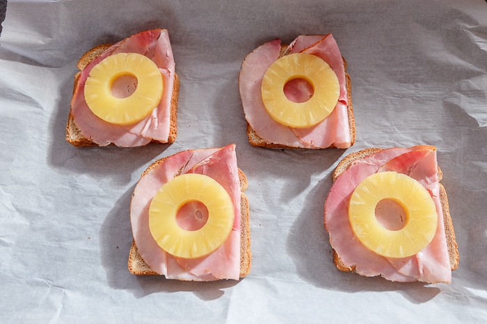 slices of round pineapple on toast hawaii on baking sheet