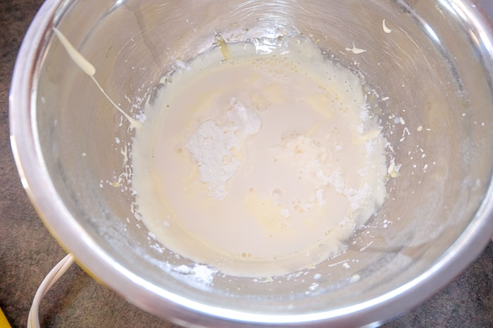 corn starch in egg yolks in silver mixing bowl