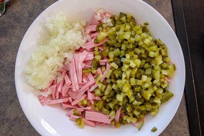 bowl of chopped onions pickles and mortadella on counter