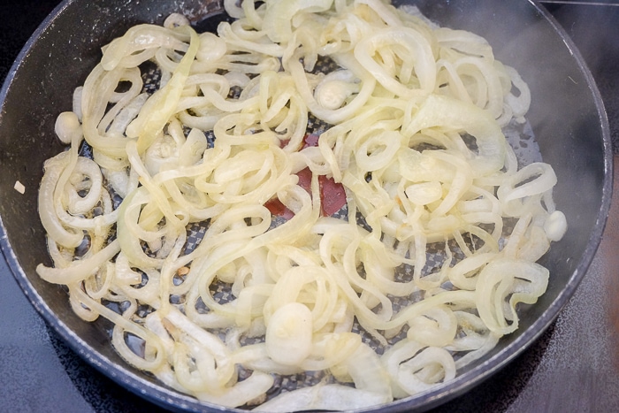 cut onions softening in black pan on stove top