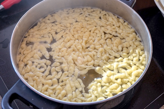 large pot on stove filled with floating german spaetzle