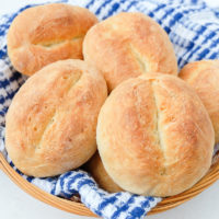 basket of german bread rolls with blue towel underneath