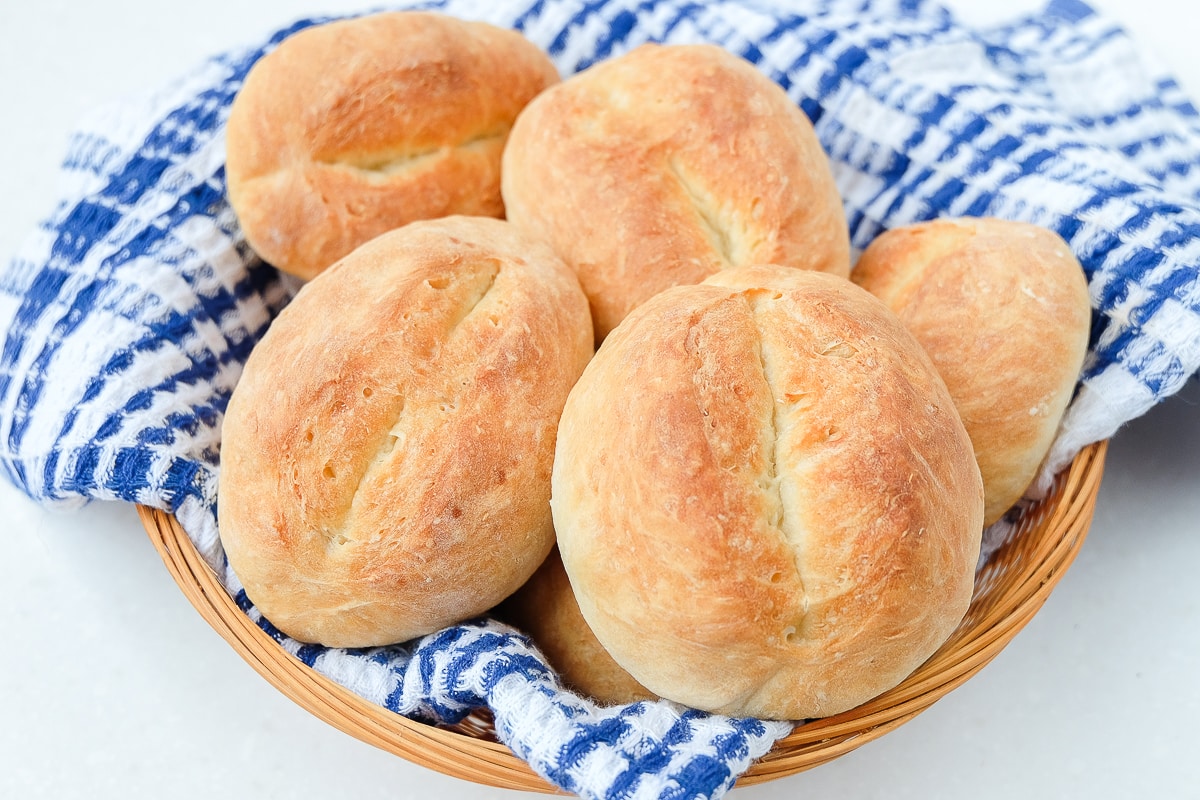 basket of german bread rolls with blue towel underneath