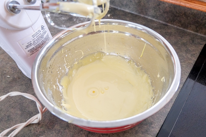 electric mixer beside mixing bowl with creamy pudding mixture inside