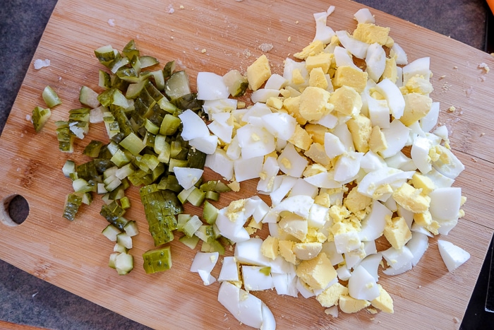 eggs and pickles chopped small on wooden cutting board