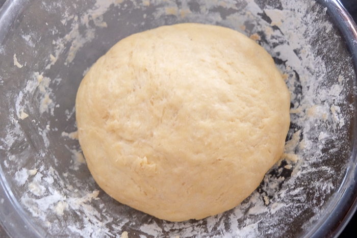 risen german butter cake dough in clear bowl