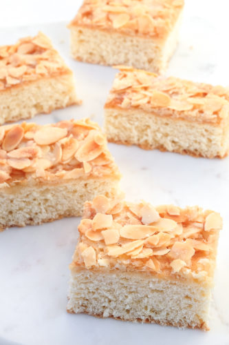 slices of german butter cake with almonds and sugar on white platter