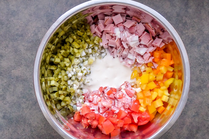 pasta salad ingredients in bowl ready to be mixed