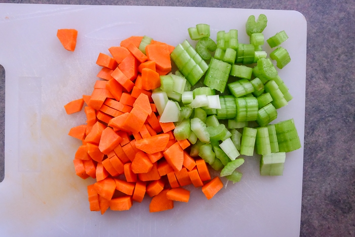 chopped celery and carrots on white cutting board