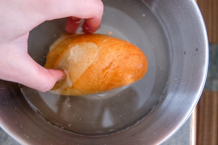 piece of bun soaking in bowl of water