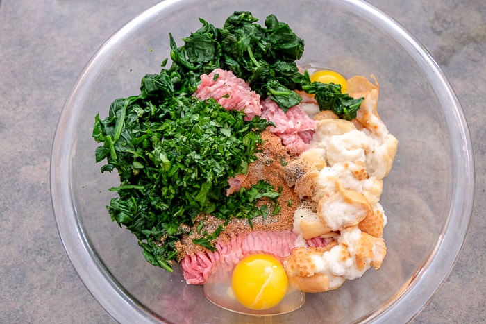 meat blend with egg and spinach in clear glass bowl on counter
