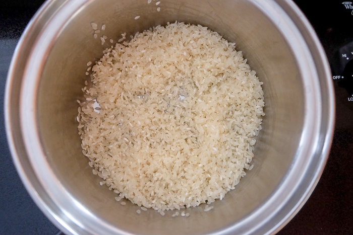 rice and butter in silver pot on stove top