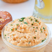 glass dish of obatzda cheese dip with pretzels behind