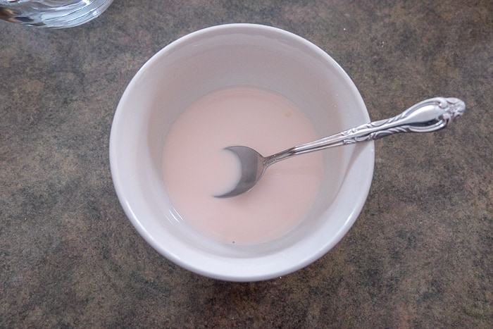 pink mixture in bowl with silver spoon on counter