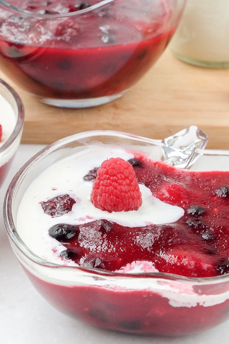 red berries dessert with cream on top in clear bowls