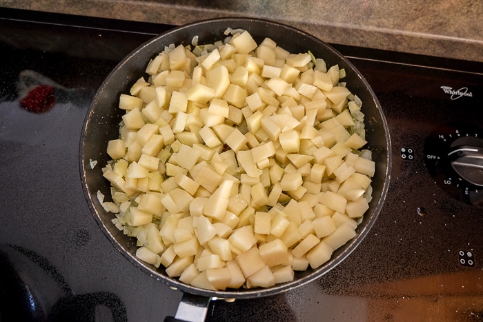 potatoes in black frying pan on stove top