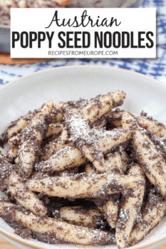 Photo of long potato noodles covered in ground poppy seeds and powdered sugar in grey bowl with text overlay saying "Austrian Poppy Seed Noodles"