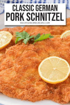 Slices of breaded and fried schnitzel on plate with slice of lemon on top plus text overlay saying "classic German pork schnitzel"