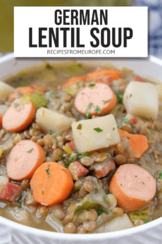 brown lentil soup with carrots, sausages and potatoes in white bowl with text overlay at the top saying "german lentil soup"
