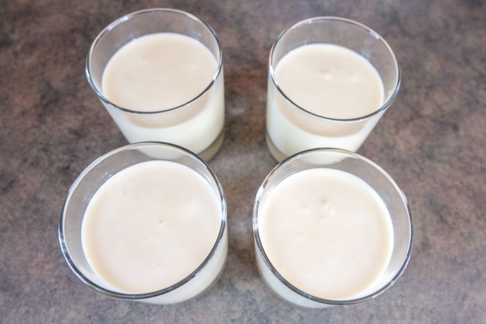 pouring bavarian cream into four glasses on counter