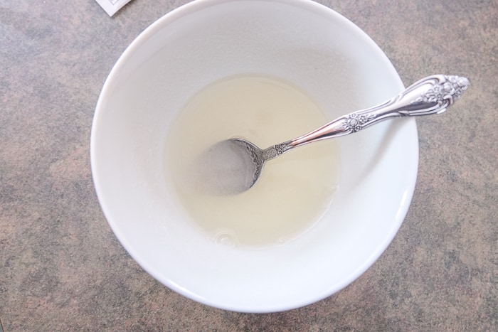 gelatin mixing in white bowl with spoon