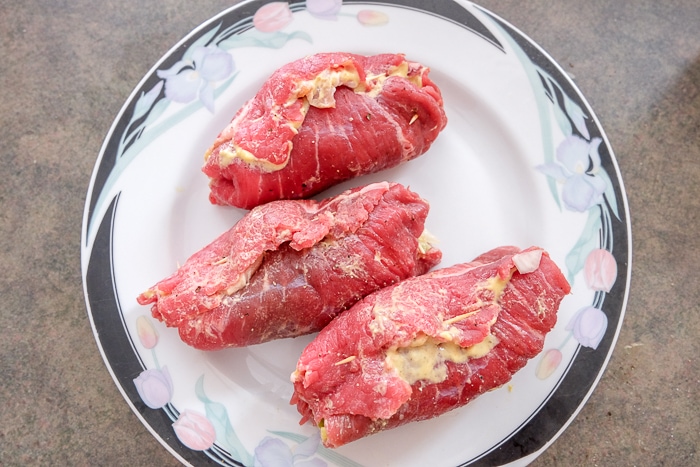 raw beef rouladen on plate on counter