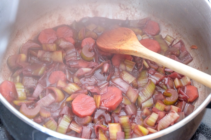 vegetables in wine sauce stirred with wooden spoon in pot