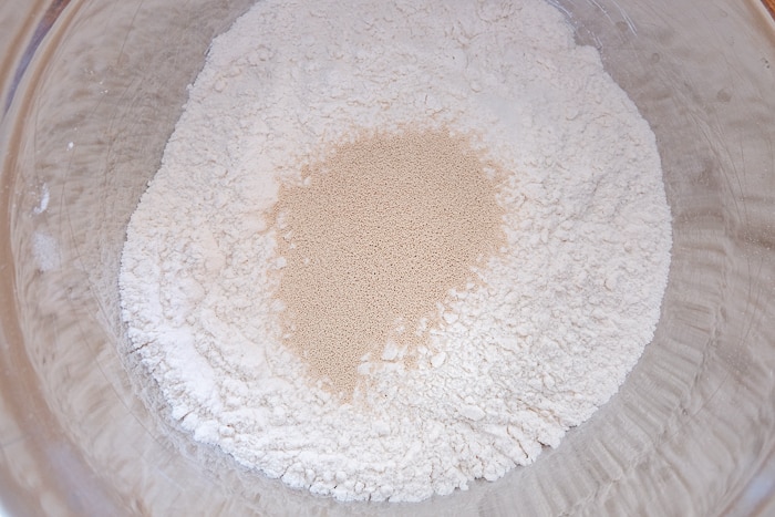 dry ingredients with yeast on top in mixing bowl
