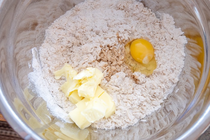 egg and flour and butter in silver mixing bowl