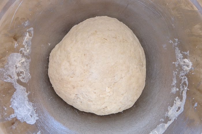 risen hefezopf dough in silver mixing bowl