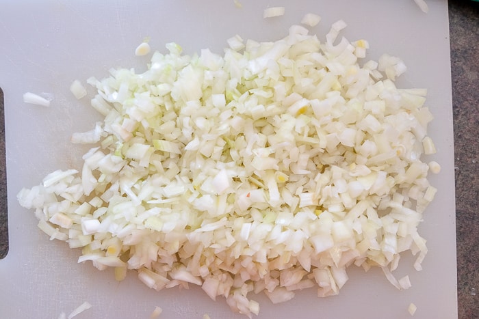 chopped onions on white cutting board on counter