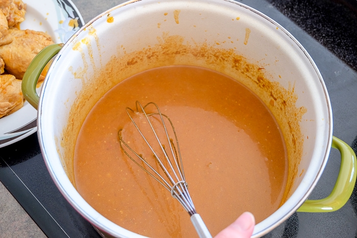 chicken paprikash sauce in pot stirred with whisk