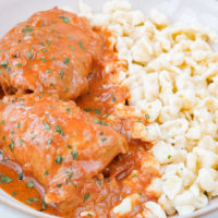 hungarian chicken paprikash with egg dumplings in white bowl