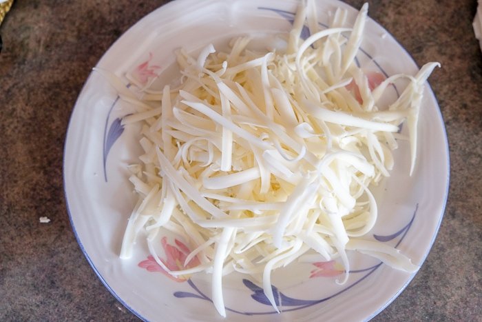 white shredded cheese on plate on counter