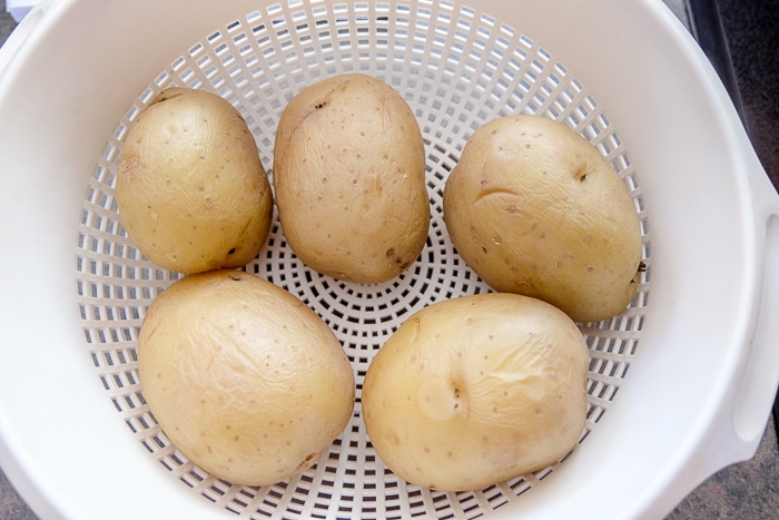 boiled potatoes sitting in white strainer