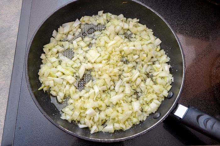 fried onions in oil in frying pan on stove