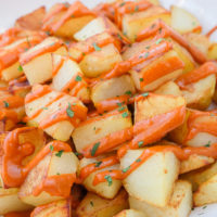 spanish fried potatoes with red sauce in bowl