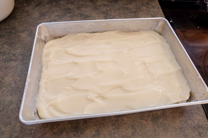 cake with vanilla pudding on top in silver pan on counter