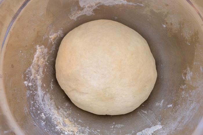 risen ball of cake dough in silver mixing bowl