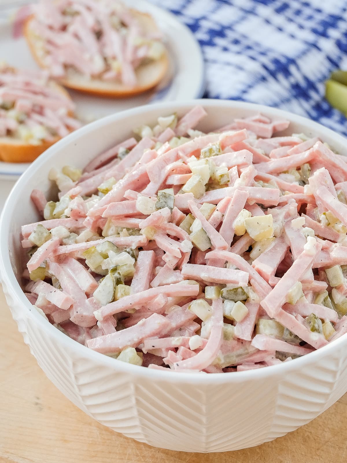 strips of sausage with pickles and onion in creamy dressing in white bowl