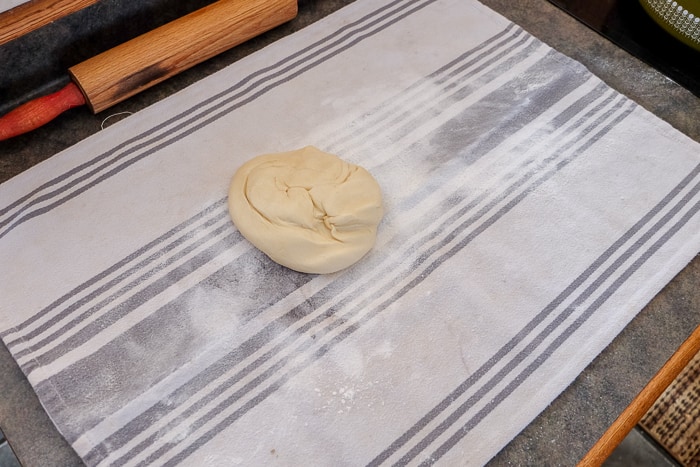 ball of apple strudel dough on dish towel on counter