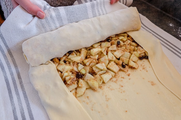 rolling up apple strudel with dish towel