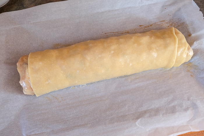 semi-cooked apple strudel on parchment paper pan