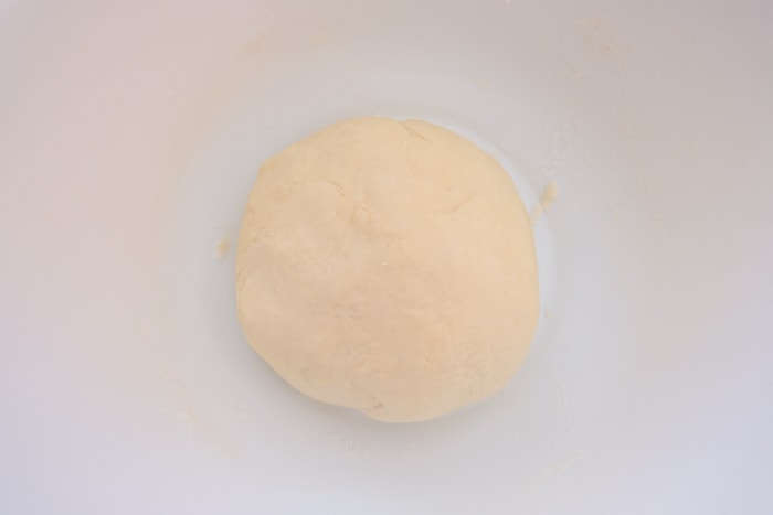 ball of pastry dough in white mixing bowl